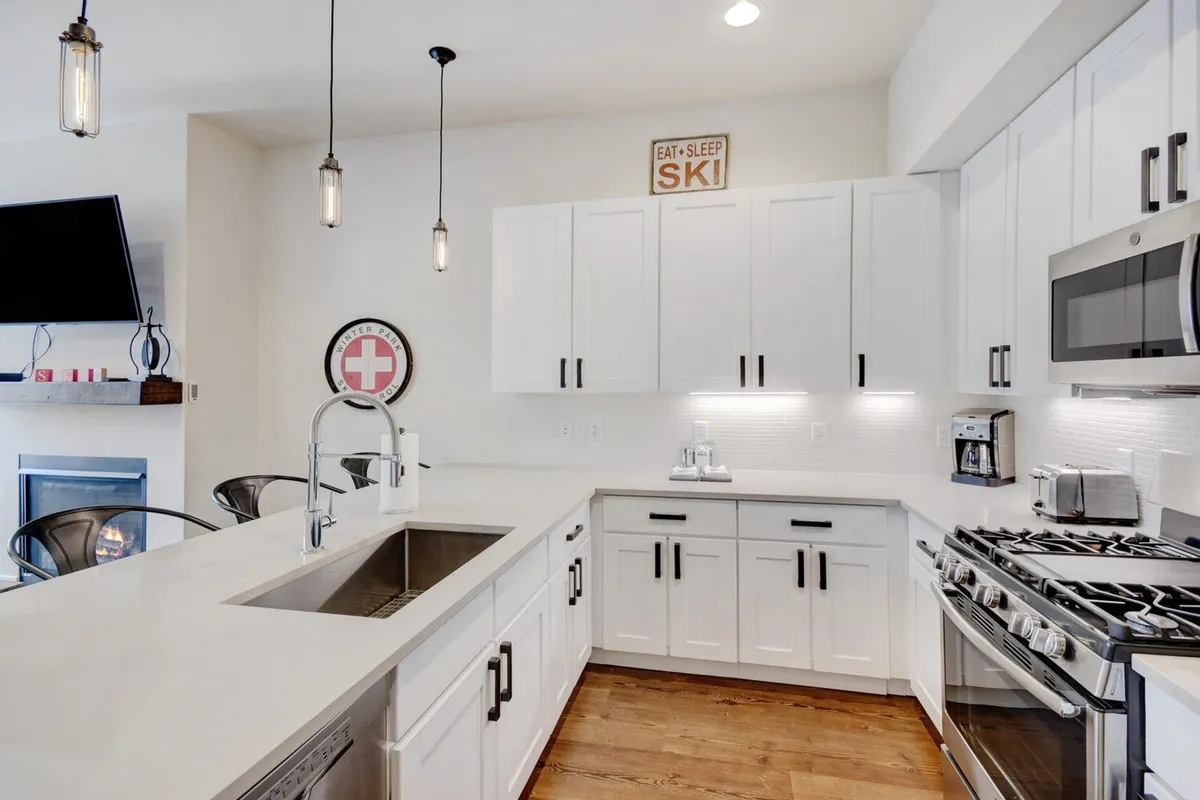 A spacious, inviting kitchen featuring a central island, stainless steel appliances, and warm wooden cabinetry. A decorative sign adds a personal touch, while ample counter space suggests an environment perfect for cooking, entertaining, and family gatherings.